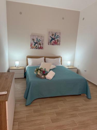 a bedroom with a bed with a green blanket at Casa Vacanze Nicol in Licata