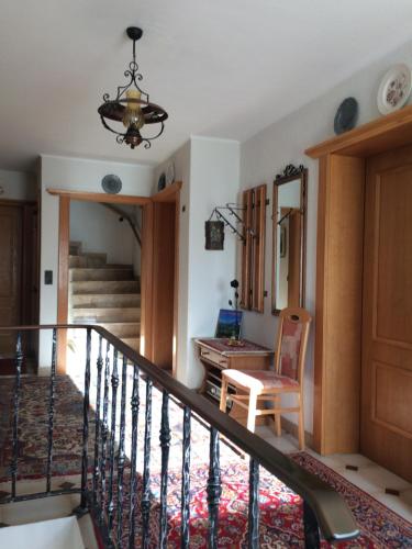 a room with a staircase with a chair and a table at Haus Bergesblick in Leutasch