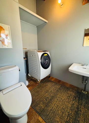 a bathroom with a toilet and a tv and a sink at AGASA residence in Fujieda