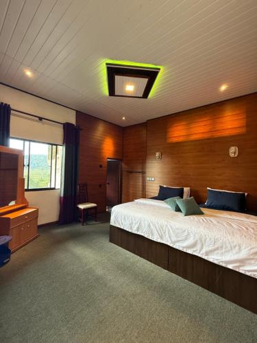 a bedroom with a large bed and a television at Roshan Guest House in Nuwara Eliya