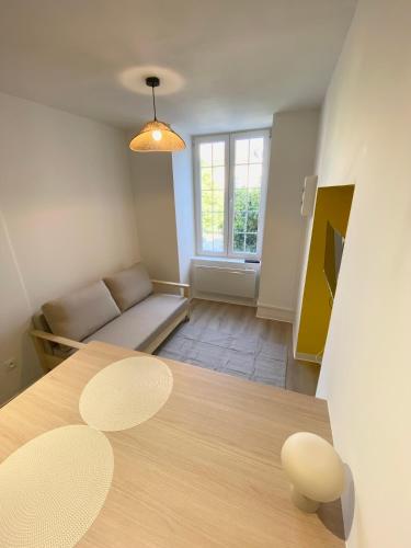 a living room with a table and a couch at Studio cosy avec jardin privé - Proche de tout ! in Montbard