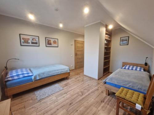 a bedroom with two beds and a closet at Apartament Blisko Lasu in Rzystnowo
