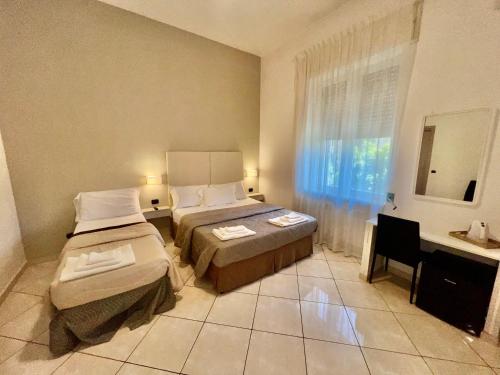 a hotel room with two beds and a sink at Tuanis in Naples