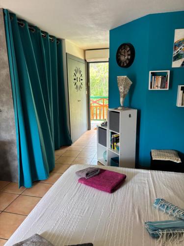 a bedroom with a bed and a blue wall at Studio Martinique in Sainte-Anne