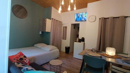 a small room with a bed and a table and a kitchen at Appartement 4 pers Montagne -draps et serviettes non fournis- in Eaux-Bonnes