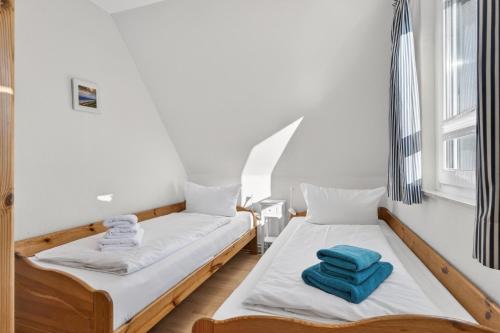 two beds in a room with two windows at Ferienwohnung Kleine Auszeit Nr 3 in Maasholm