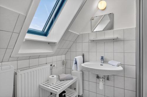 a white bathroom with a sink and a window at Ferienwohnung Kleine Auszeit Nr 3 in Maasholm