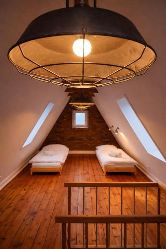 a attic room with two beds and a chandelier at Ferienhaus in Graal-Müritz in Graal-Müritz