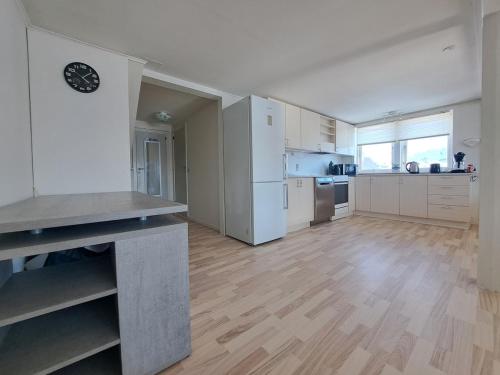 a large kitchen with white appliances and a wooden floor at Michelle's Yellow house in Ilulissat