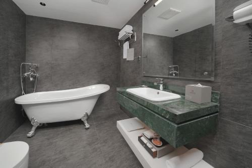 a bathroom with a tub and a sink and a toilet at Marvelous Hotel in Tabuk
