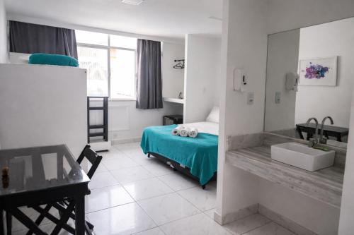 a bedroom with a bed and a sink and a desk at REF House Barra Da Tijuca in Rio de Janeiro