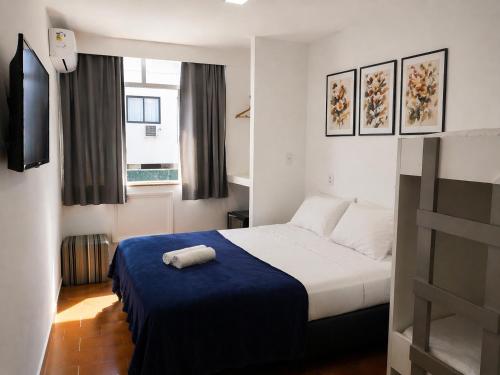 a hotel room with a bed with a blue blanket at REF House Barra Da Tijuca in Rio de Janeiro