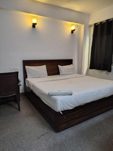 a bedroom with a large bed with white sheets at Hotel king palace family stay in Agra