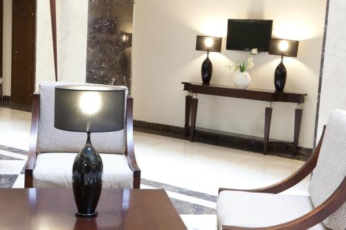 a lamp sitting on a table in a room with chairs at Europa Royale Bucharest in Bucharest