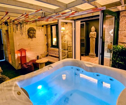 a jacuzzi tub in a room with a statue at Les suites du Bouddha Bleu in Carnac