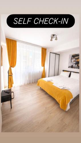 a bedroom with a bed with a yellow blanket at Yellow Apartment in Floreşti