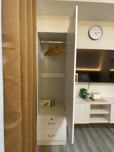 a white closet with a clock on the wall at Iam Cozy Condo Mactan Airport in Lapu Lapu City