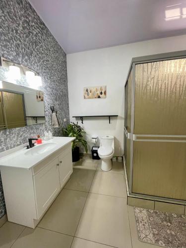 a bathroom with a sink and a toilet at Arenal Views, Pool & 5min to Waterfall & Town in Fortuna