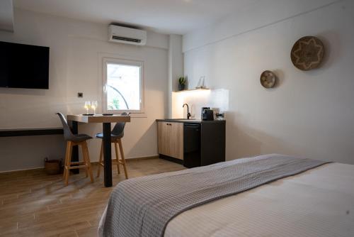 a bedroom with a bed and a desk and a table at Τzegia Suites in Galissas