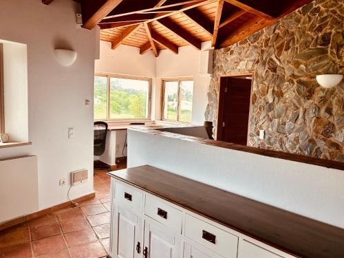 a kitchen with a counter and a stone wall at Moonshine Studios Lagos in Lagos