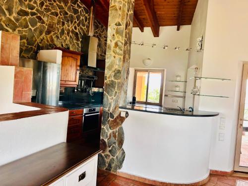 a kitchen with a counter and a stone wall at Moonshine Studios Lagos in Lagos