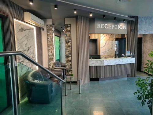 a lobby with a reception desk and leather chairs at Korona Hotel in Blagoevgrad
