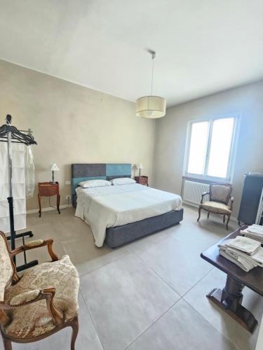 a bedroom with a bed and a table and chairs at Locazione turistica Corner 20 zona Clinica Piacenza in Piacenza