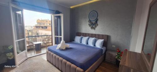 a bedroom with a large bed with a balcony at Elite Apartment In Cairo Downtown in Cairo
