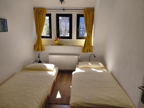 two beds in a room with two windows at Ferienwohnung Twete in Detmold