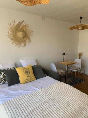 a bedroom with a bed and a table with chairs at Waterfront studio with small garden, pool, parking in Guidel