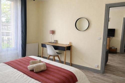 a bedroom with a bed and a desk and a mirror at T2 cosy & calme - Gare à 1 min accès direct Paris & CDG in Aulnay-sous-Bois