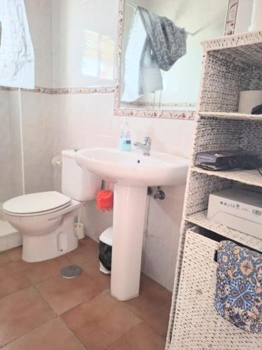 a bathroom with a sink and a toilet and a mirror at las olas in Chipiona