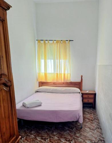 a small bed in a room with a window at las olas in Chipiona