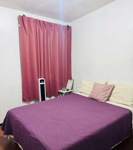 a bedroom with a purple bed in front of a window at Casa Inteligente Anys in Tampico