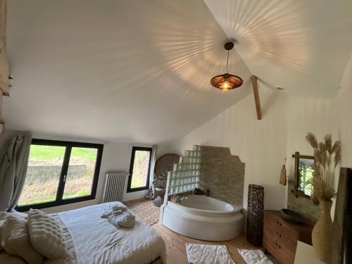 a bedroom with a bed and a bath tub at Hameau Fleuri in Pierrefitte-en-Auge