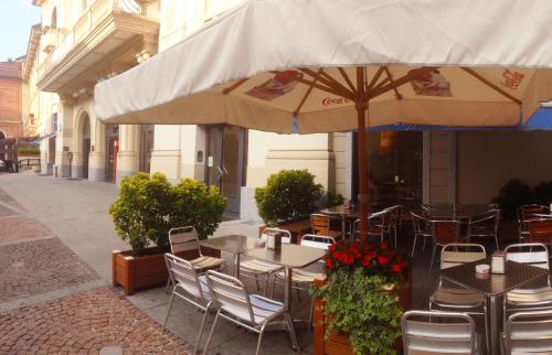 an outdoor cafe with tables and chairs and an umbrella at Locanda San Paolo in Monza