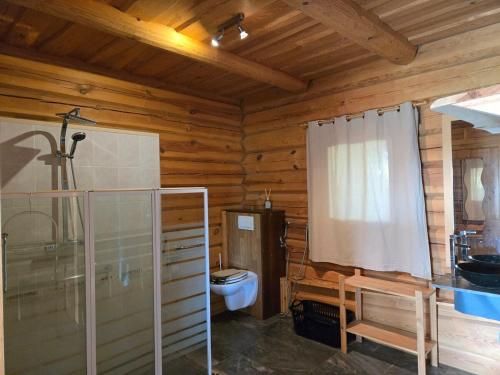 a bathroom with a toilet in a wooden cabin at Charmante Fuste in Lubersac