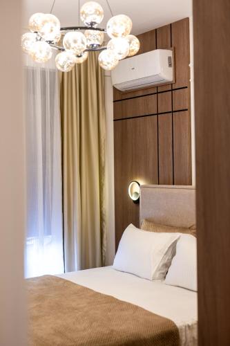 a bedroom with a bed and a chandelier at Lux residence Adrijana 1 in Ulcinj