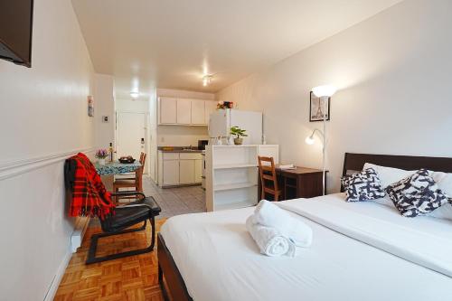 a small room with two beds and a kitchen at Comfort Residence in Montreal