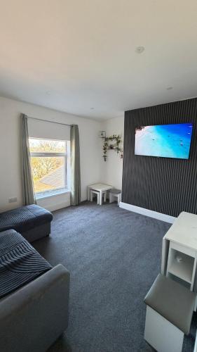 a living room with a couch and a tv on a wall at Beach & city Homestay in Waterloo