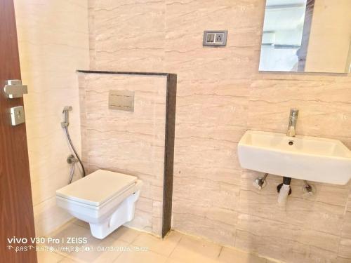 a bathroom with a toilet and a sink at Apex Inn Gulf View in Bangalore