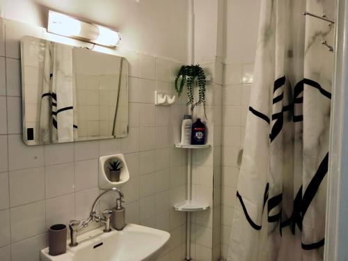 a white bathroom with a sink and a mirror at ON THE SAND apartment in Artemida