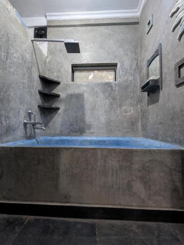 ein Badezimmer aus Beton mit Waschbecken und Treppe in der Unterkunft The Double V Experience in Arambol