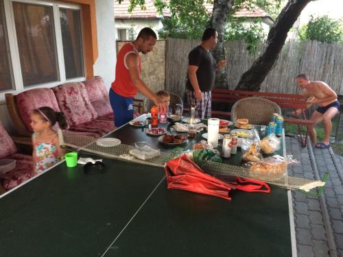 a group of people standing around a table with food at Famvarga Apartmanház in Balatonfenyves