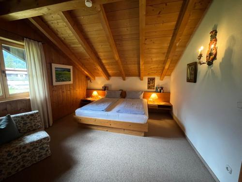 a bedroom with a bed and a couch in a room at Frühholz - Das Ferienhaus - in Grainau