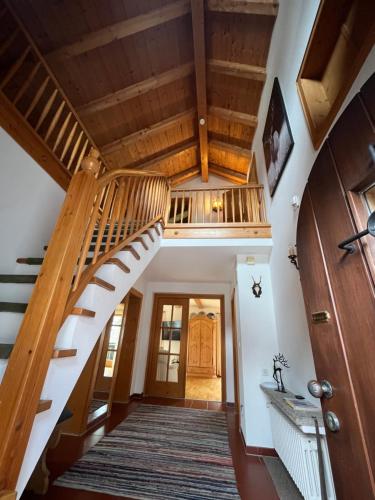 a winding staircase in a house with wooden ceilings at Frühholz - Das Ferienhaus - in Grainau