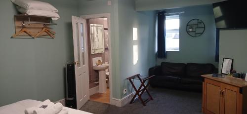 a living room with a black couch and a sink at The Crafty Cow in Bristol