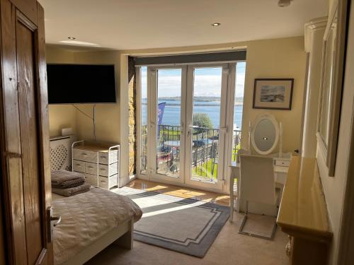 a bedroom with a balcony with a view of the ocean at The View in Tynemouth