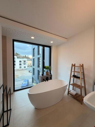 a large white bath tub in a bathroom with a window at Alte Weberei in Marktredwitz