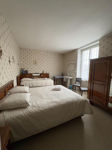 a bedroom with two beds and a window at Gîte Chez Mamie Madeleine in Ainay-le-Château